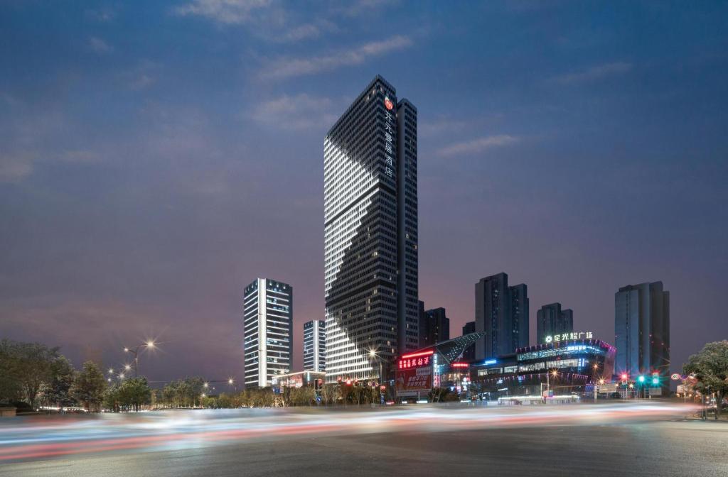 a tall building in a city at night at Manju Hotel in Nantong