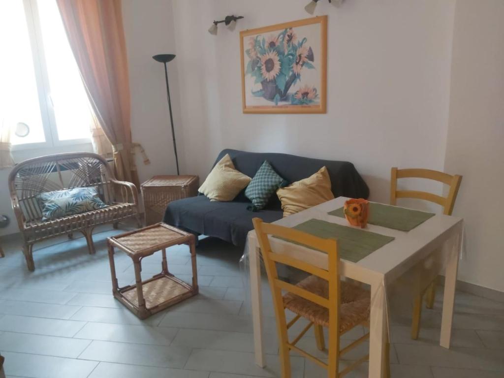 uma sala de estar com um sofá e uma mesa com cadeiras em Casa del Cioccolatte em Gênova