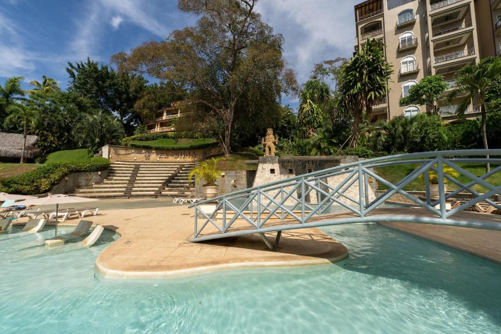 a bridge over a swimming pool in a building at Matapalo 204- 2 Bedroom Condo At Tamarindo in Tamarindo