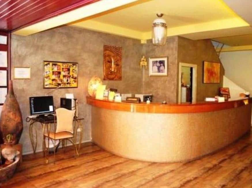 a bar in a room with a desk with a laptop at Pasadena Lodge in Pattaya Central