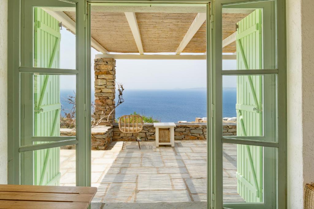 an open door to a patio with a view of the ocean at Casa Xyla-sunset view villa in Melissaki