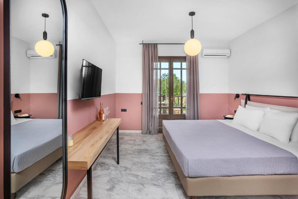a hotel room with two beds and a tv at Estival Concept in Paliouri