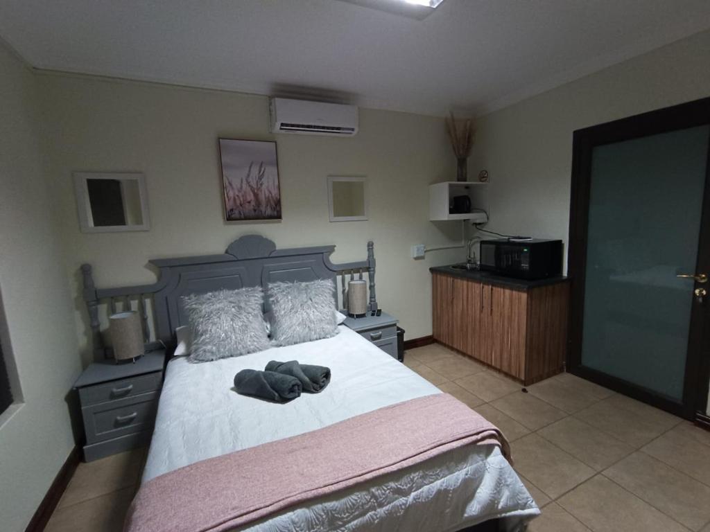 een slaapkamer met een bed met twee schoenen erop bij Bello Guest in Bloemfontein