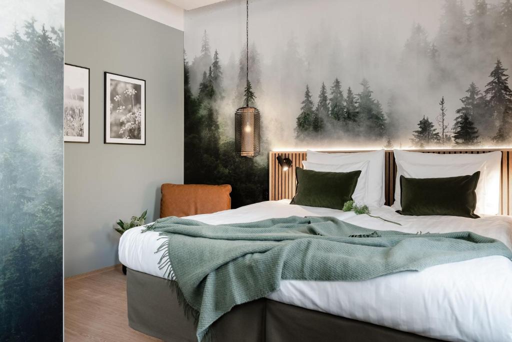 a bedroom with a large bed with a green blanket at Original Sokos Hotel Koljonvirta in Iisalmi