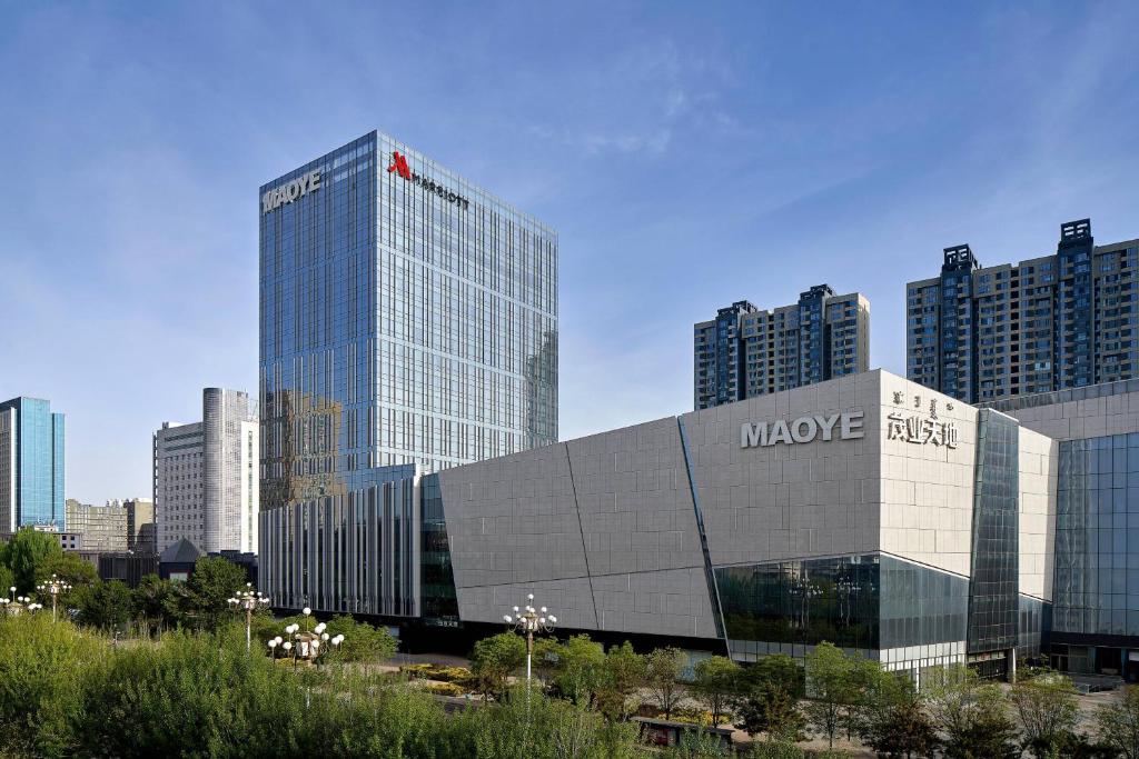 a large building in a city with tall buildings at Baotou Marriott Hotel in Baotou