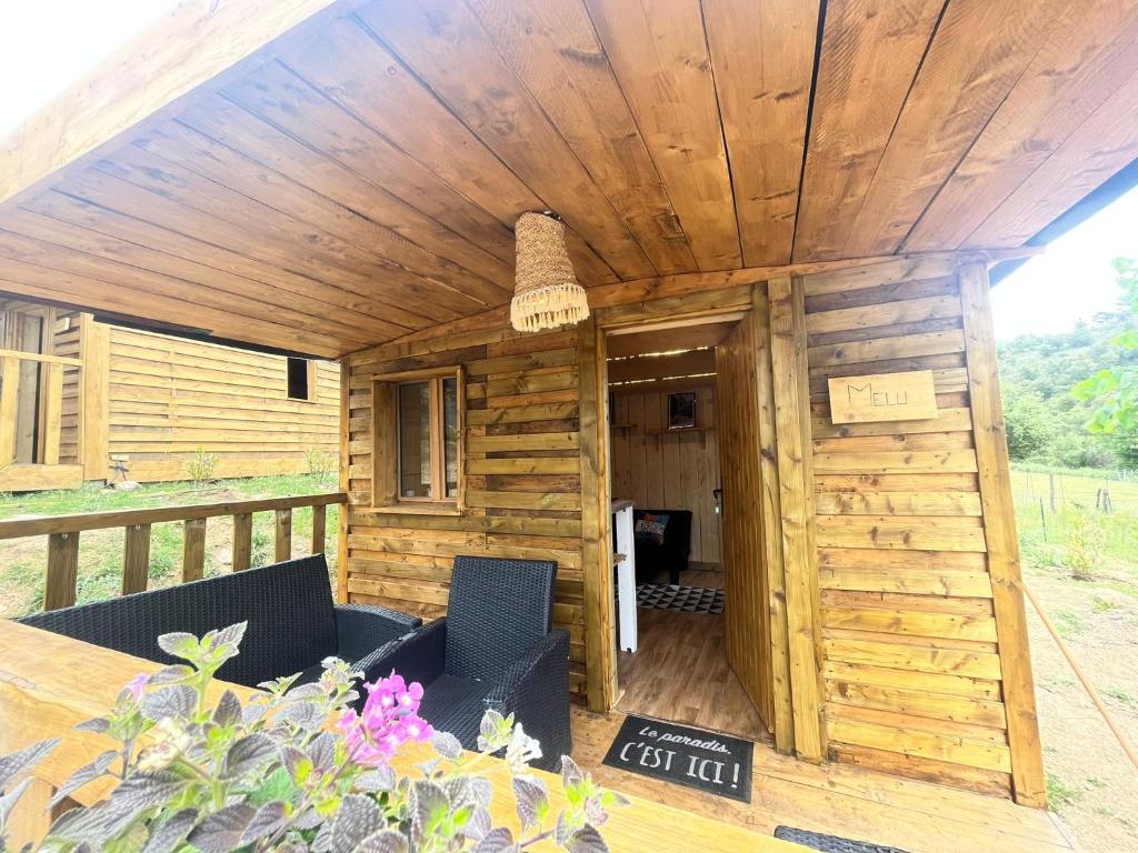 een houten hut met 2 stoelen en een tafel bij La Cabane de Mercone MELU in Corte