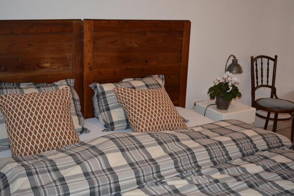 a bedroom with a bed with a wooden headboard and pillows at Apartma Raft, Bovec in Bovec