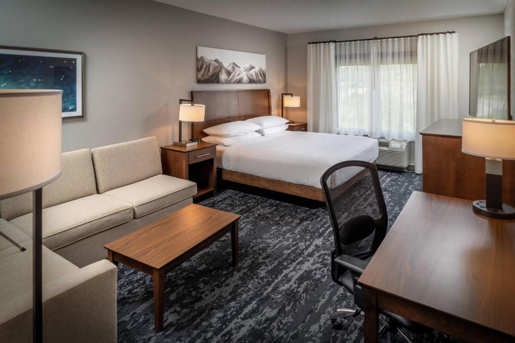 um quarto de hotel com uma cama e um sofá em Delta Hotels by Marriott Huntington Mall em Barboursville