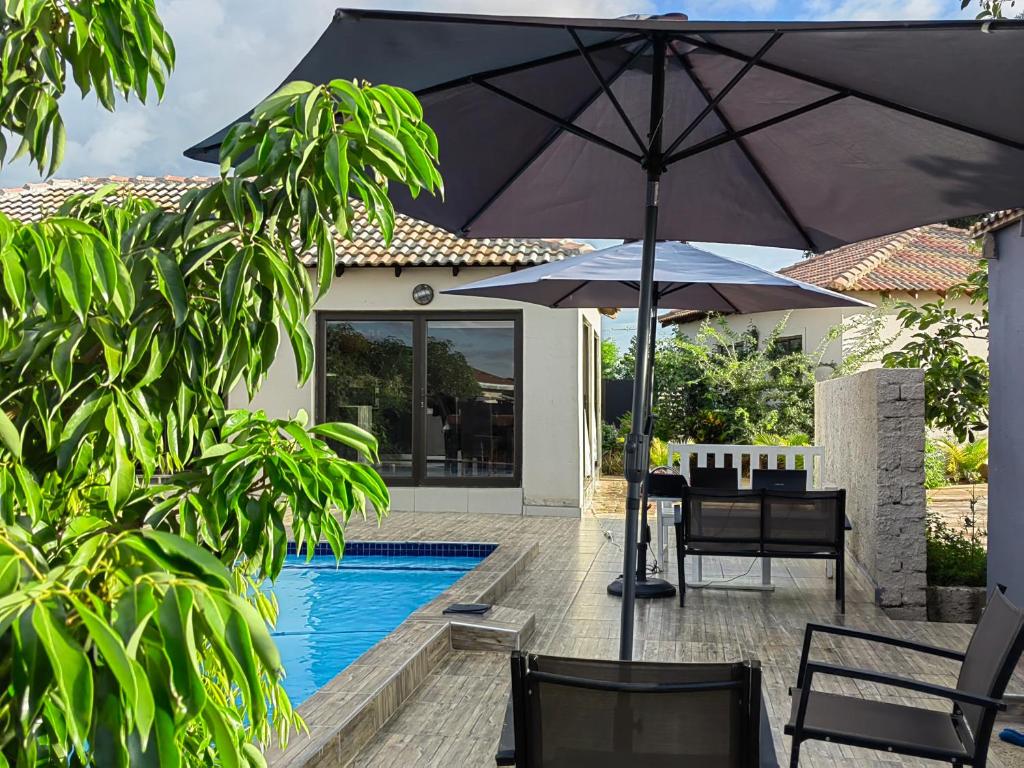 een patio met een tafel en een parasol naast een zwembad bij Nandoni Crystal in Thohoyandou