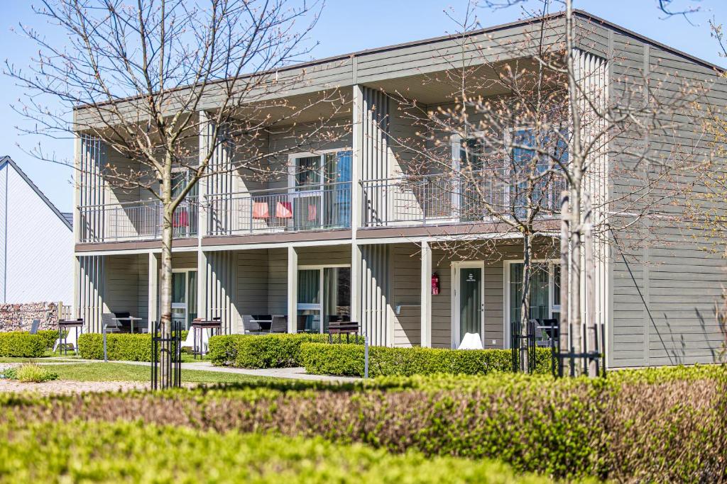 a house with a balcony on the side of it at Ramios bitės in Palanga