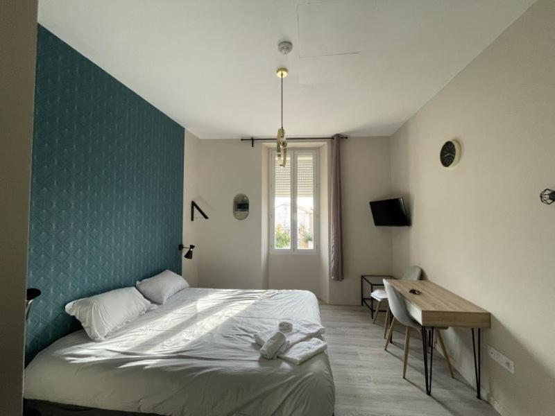 a bedroom with a bed and a desk in it at Appart'Hôtel Sous Les Pins in Martigues