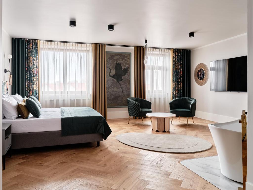 sypialnia z łóżkiem, stołem i krzesłami w obiekcie Hoppen House Apartamenty w centrum miasta w Radomiu