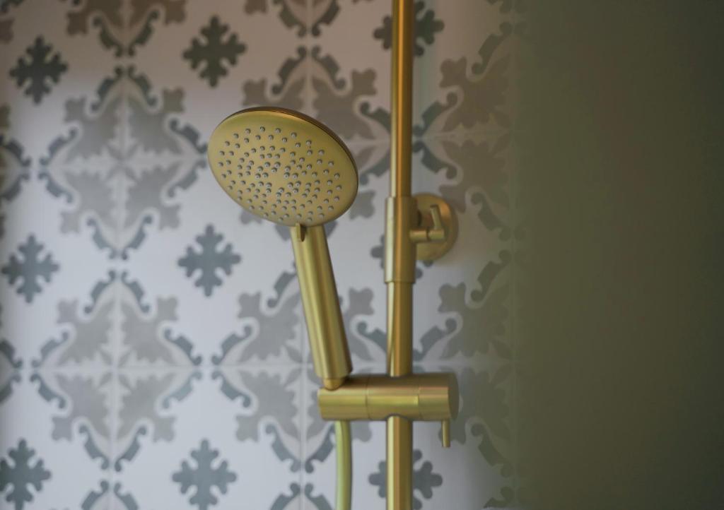 a wall mounted shower head in a bathroom at Pafsilipon Suites in Ermoupoli
