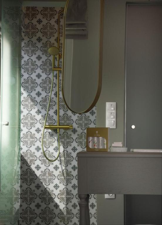 a bathroom with a shower with a mirror and a sink at Pafsilipon Suites in Ermoupoli