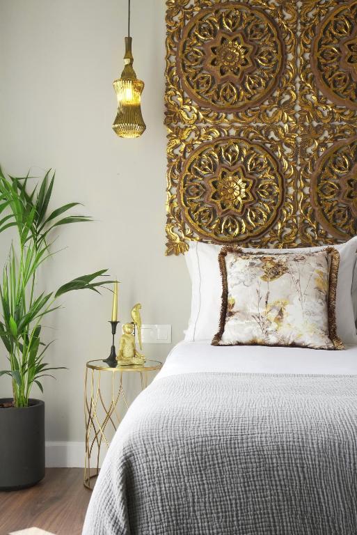 a bedroom with a bed with a gold headboard at Pafsilipon Suites in Ermoupoli