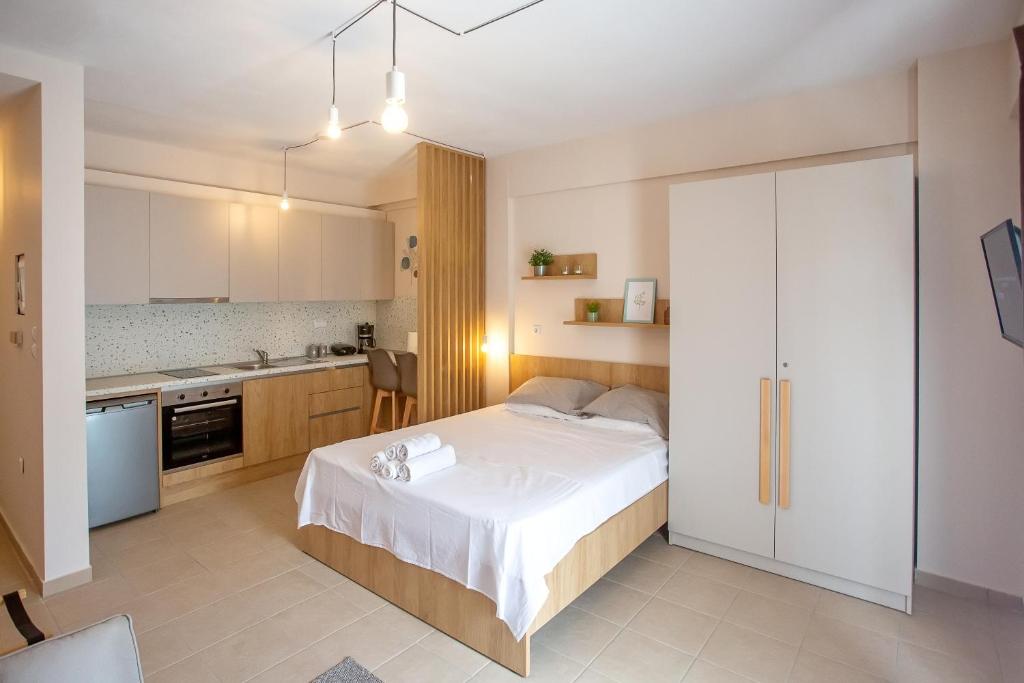 a bedroom with a large bed and a kitchen at PeramoBello in Nea Peramos