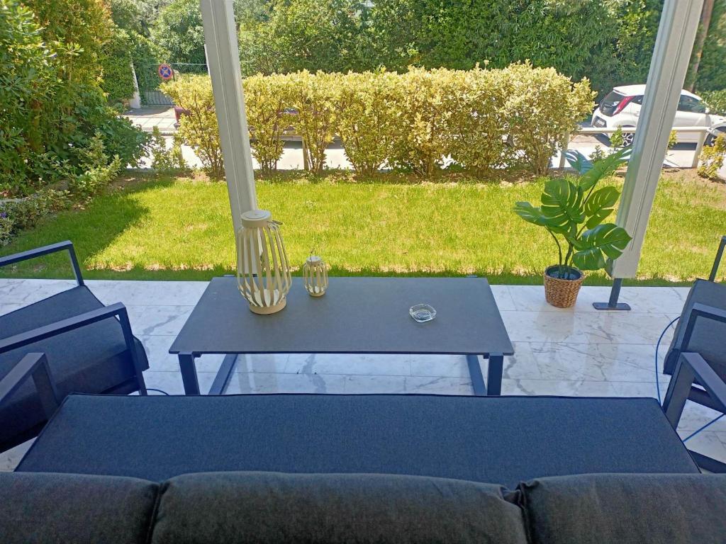 a blue table sitting on a porch with a couch at DM Villa - quality stay in Perea, Thessaloniki, Greece in Perea