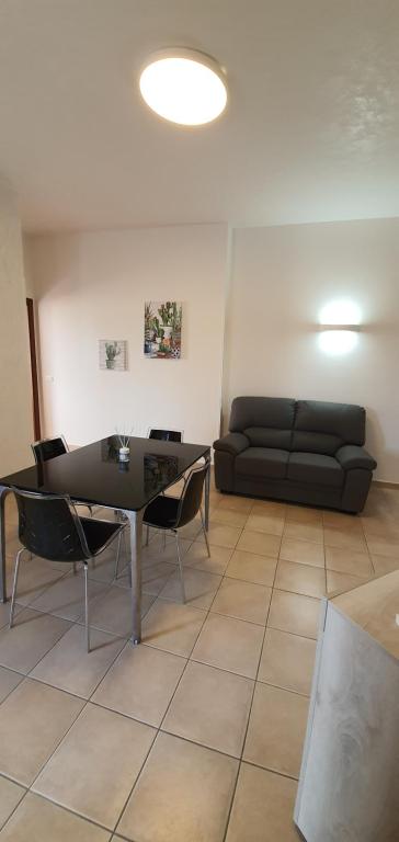 sala de estar con sofá, mesa y sillas en Lovely house tra pineta e mare, en Torre di Montalto