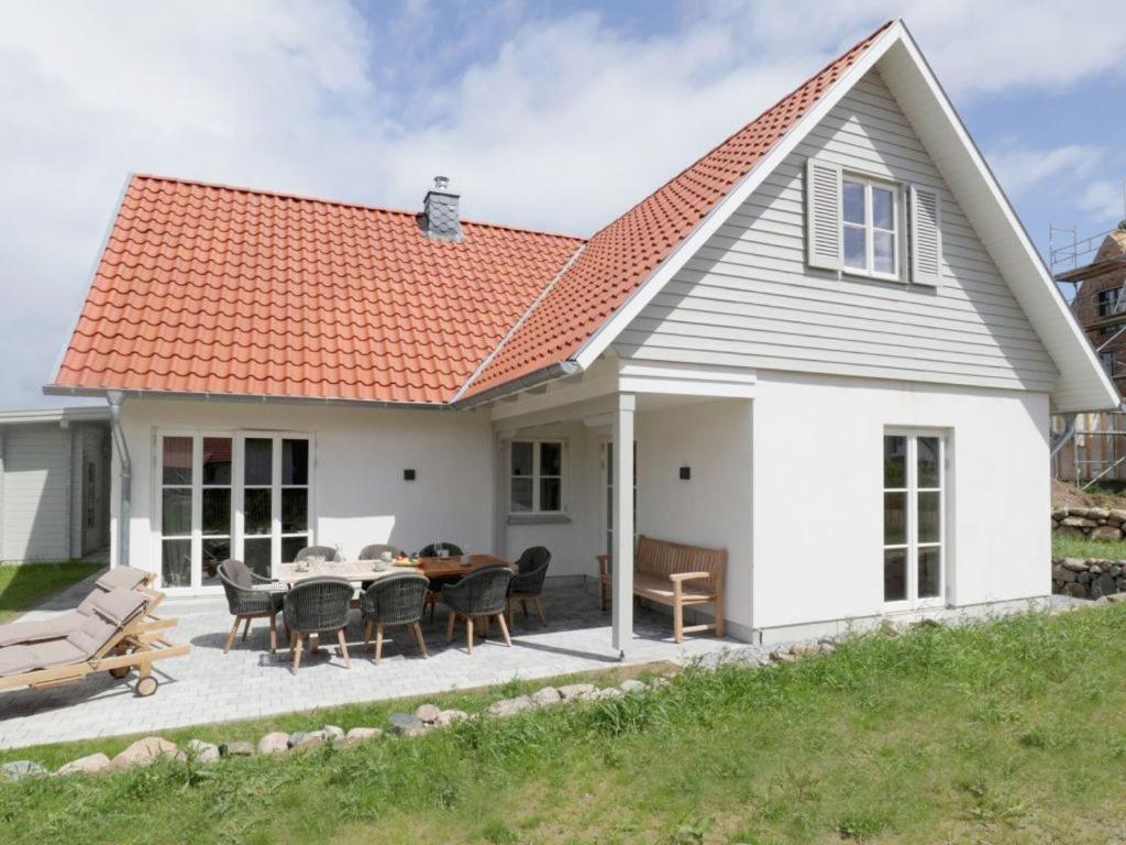 een wit huis met een tafel en stoelen bij Strandheimat in Groß Schwansee