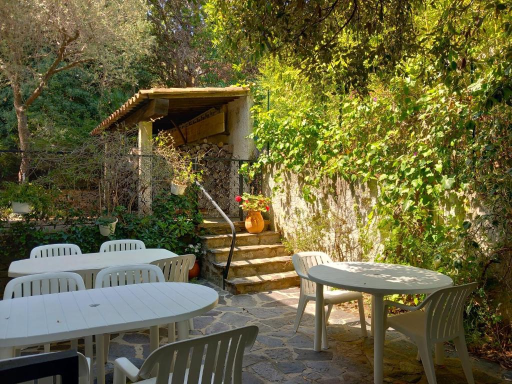 - un ensemble de tables et de chaises dans un jardin dans l'établissement Hôtel Cap Soleil, à Cavalaire-sur-Mer