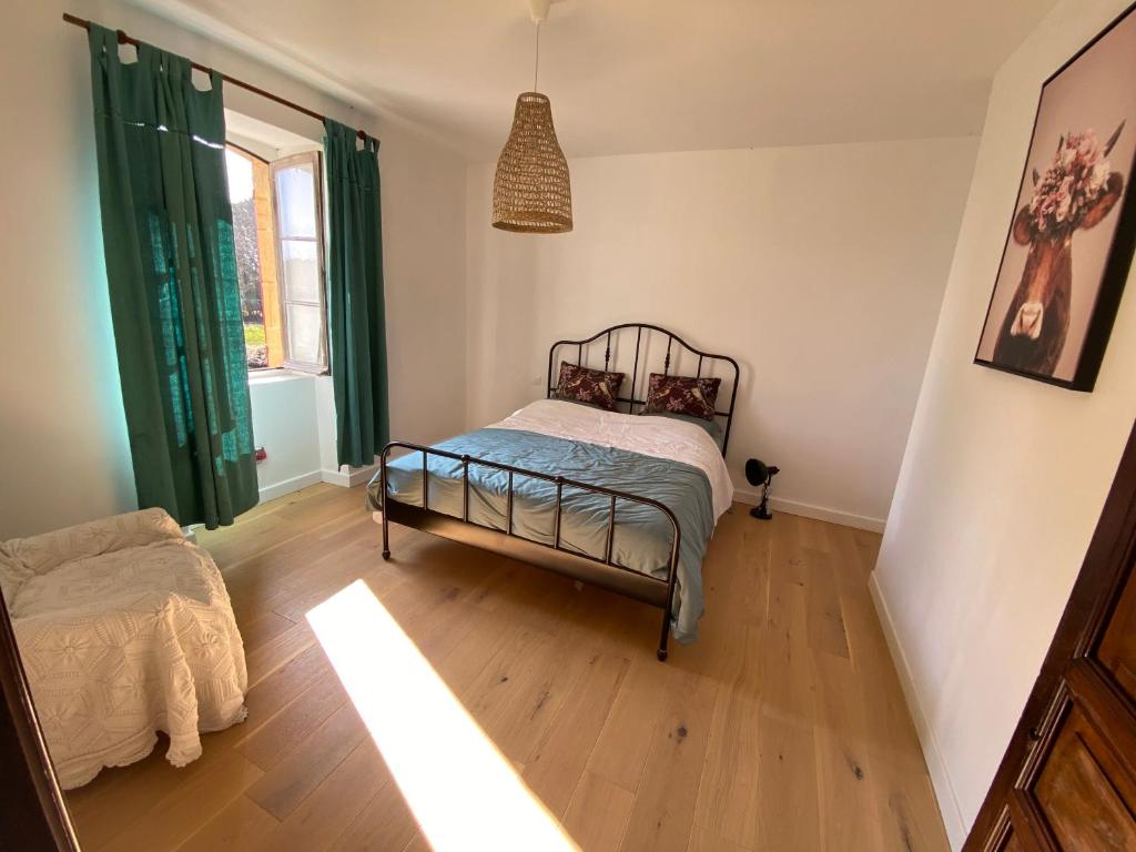 1 dormitorio con 1 cama y suelo de madera en La chambre du tilleul en Capdrot