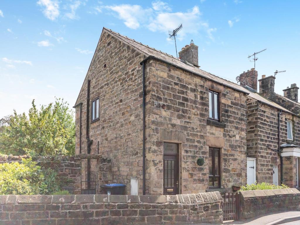 an old brick building on a street at River Cottage in Two Dales