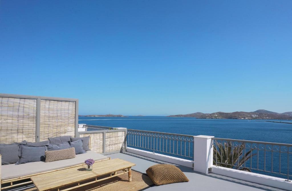 a balcony with a couch and a view of the water at Pafsilipon Suites in Ermoupoli