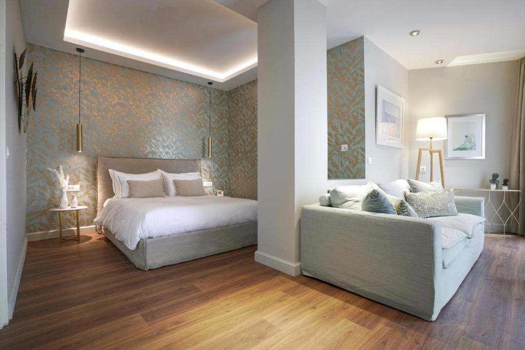 a bedroom with a bed and a couch at Pafsilipon Suites in Ermoupoli