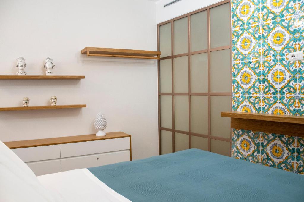 Un dormitorio con una cama y una pared con una cortina. en Taonasi Taormina City Apartment, en Taormina