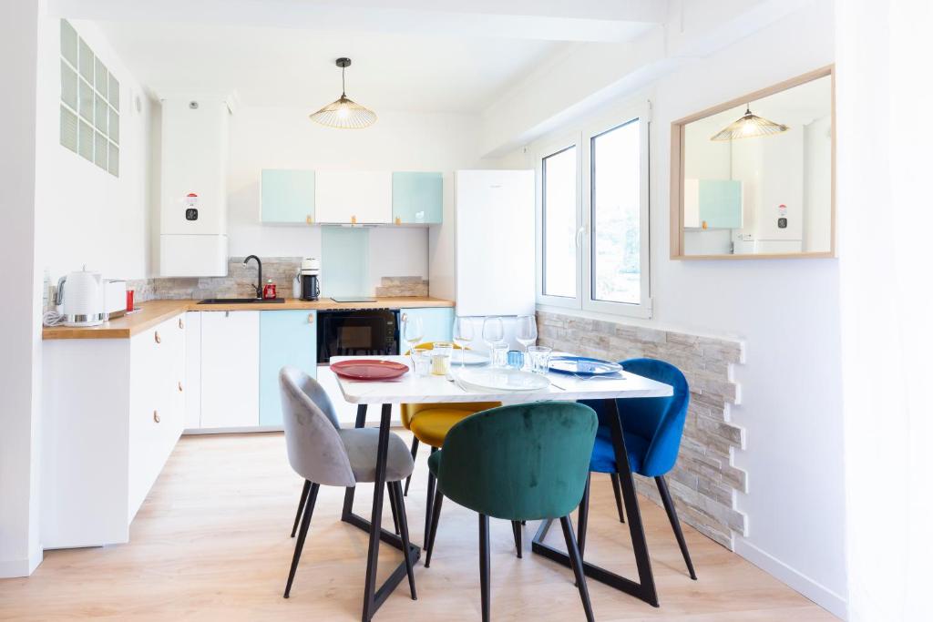 a white kitchen with a table and chairs at EDOUARD VII - STUDIO - Carré d'or Menton in Menton