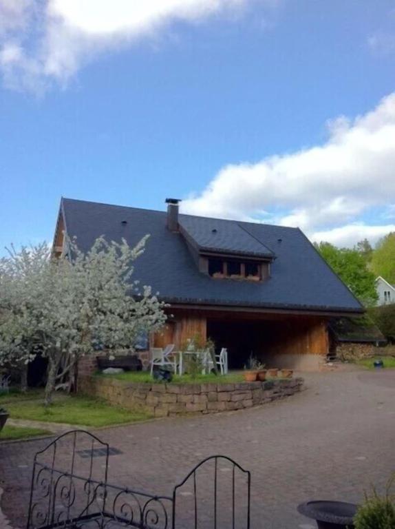 a house with a black roof and a yard at Lodjadis in Labaroche