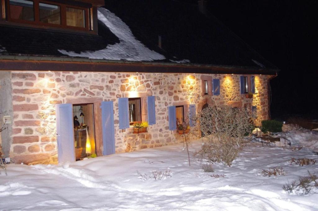 a stone house in the snow with lights on it at Lodjadis in Labaroche