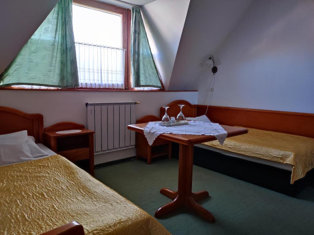 Habitación con 2 camas y mesa con fregadero en Ágnes Hotel, en Hévíz