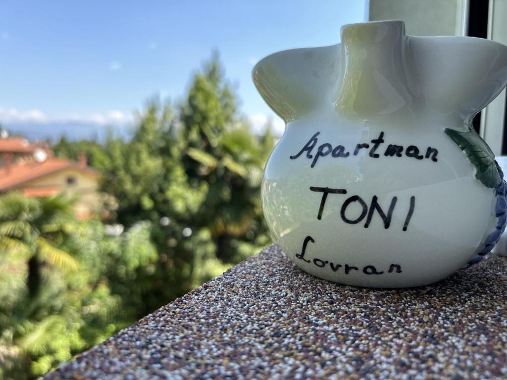 een vaas op een vensterbank met de woorden April turn istg bij Apartment Toni in Lovran