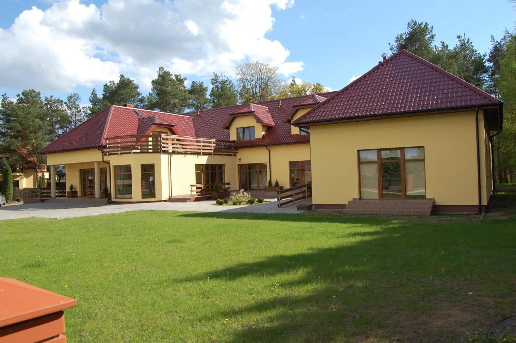 Rezydencja Nad Wigrami Standard & Comfort Rooms في Gawrych Ruda: منزل أمامه ساحة كبيرة