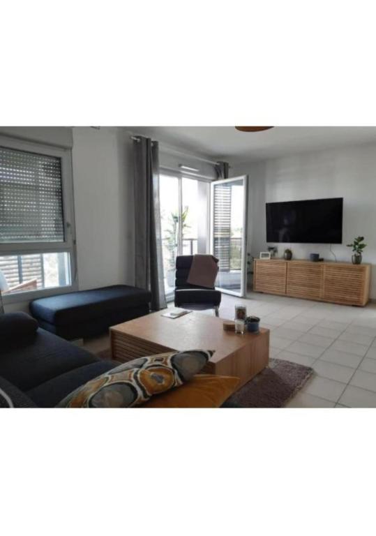 een woonkamer met een bank en een salontafel bij Casa Lione - Appartement Moderne à Décines in Décines-Charpieu