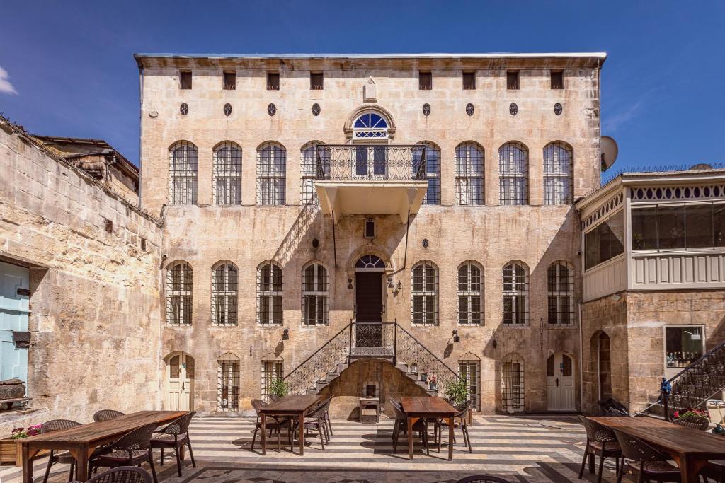 a large brick building with tables and chairs at Anadolu Evleri in Gaziantep
