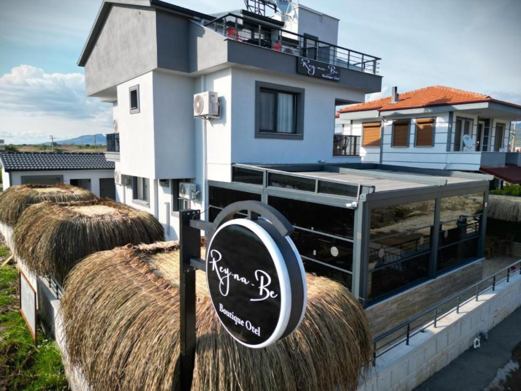 een bord voor een huis met hooibergen bij ReynaBe Boutique Hotel in Dikili