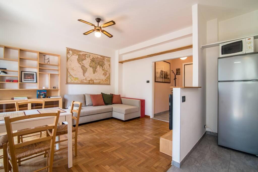 a kitchen and living room with a couch and a refrigerator at enJoy Home - Bilocale sulle Riviere a due passi dalla Specola in Padova