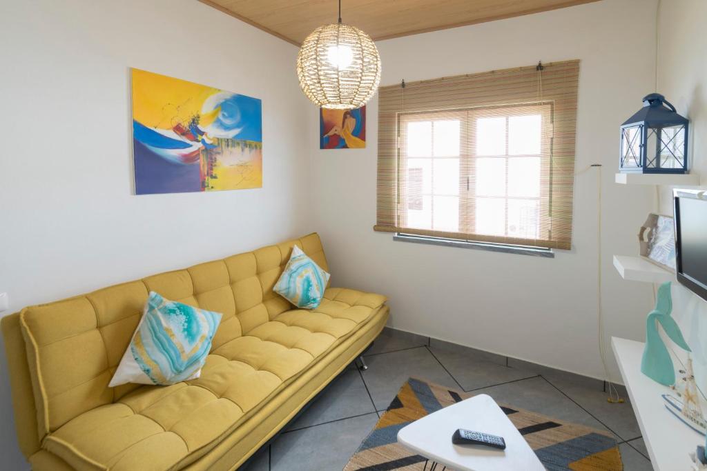 uma sala de estar com um sofá e uma janela em Casa da Avó em Alcácer do Sal
