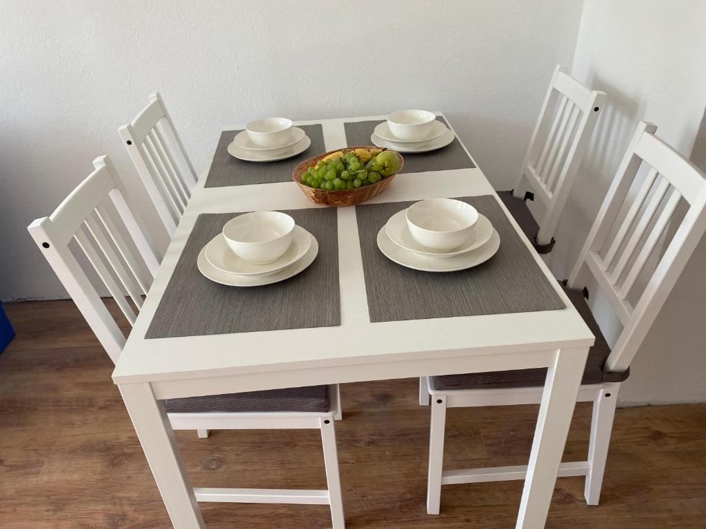 コペルにあるApartmani Mateja2の白いテーブル(椅子付)とフルーツの盛り合わせ