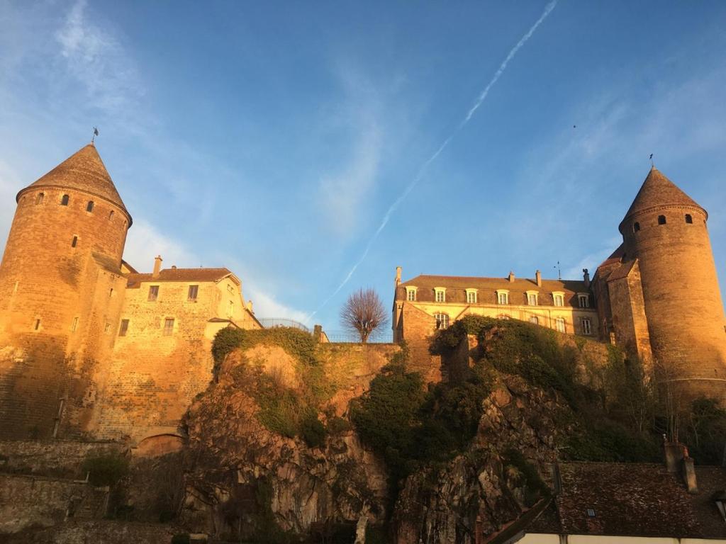 un château avec deux tours au sommet d'une montagne dans l'établissement Grande Maison à Semur en plein coeur Historique, à Semur-en-Auxois