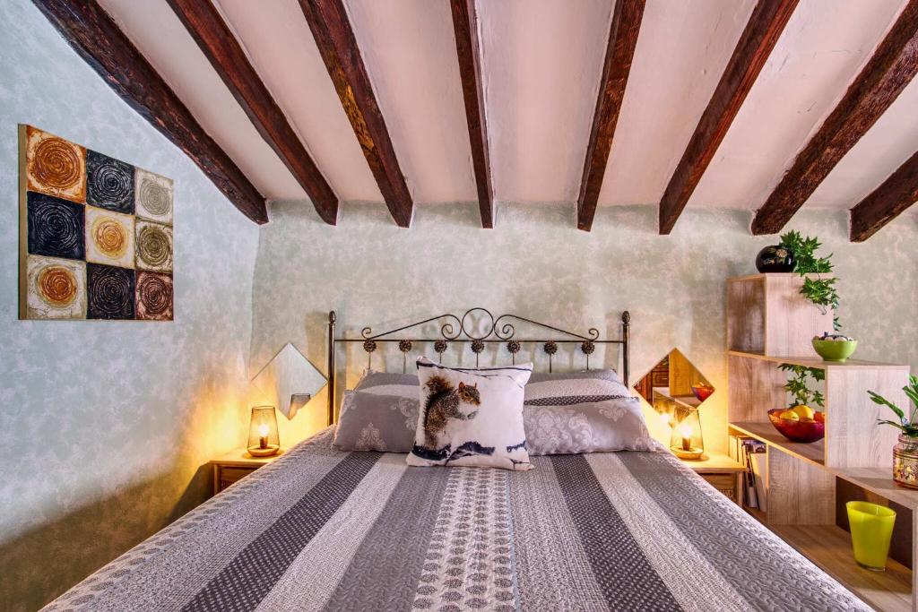 a dog sitting on a bed in a bedroom at The Nook (El Recoveco) in Canillas de Aceituno