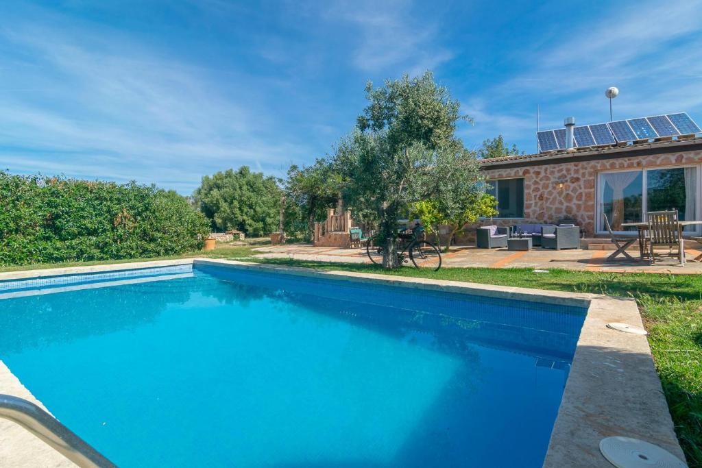 a blue swimming pool in front of a house at Son Blau in Llucmajor