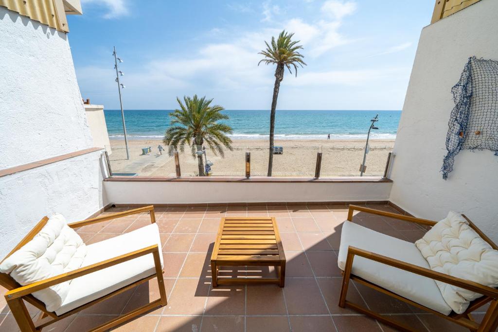 a balcony with chairs and a view of the beach at Calafellmar loft in Calafell