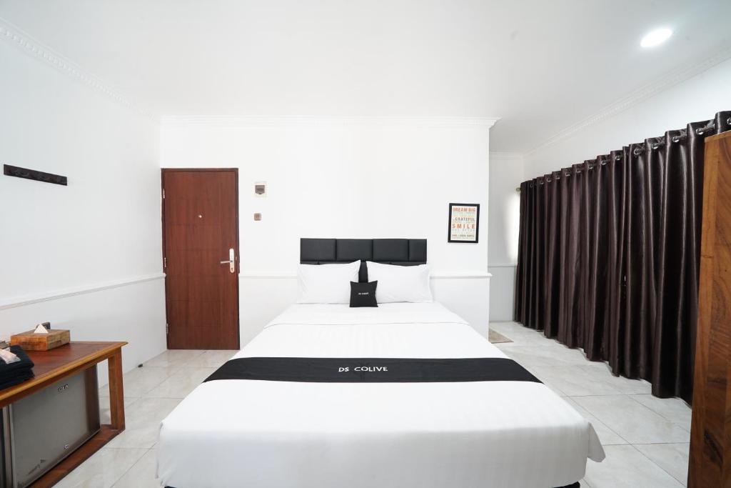 a hotel room with two beds and a tv at DS Colive Marina in Semarang