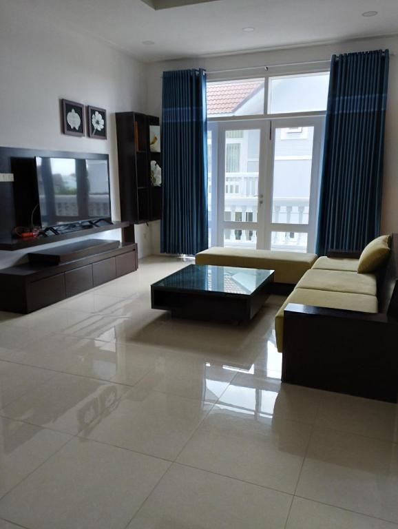 ein Wohnzimmer mit einem Sofa und einem TV in der Unterkunft Villa Sealinks Phan Thiết 3PN View bien in Ấp Ngọc Hải