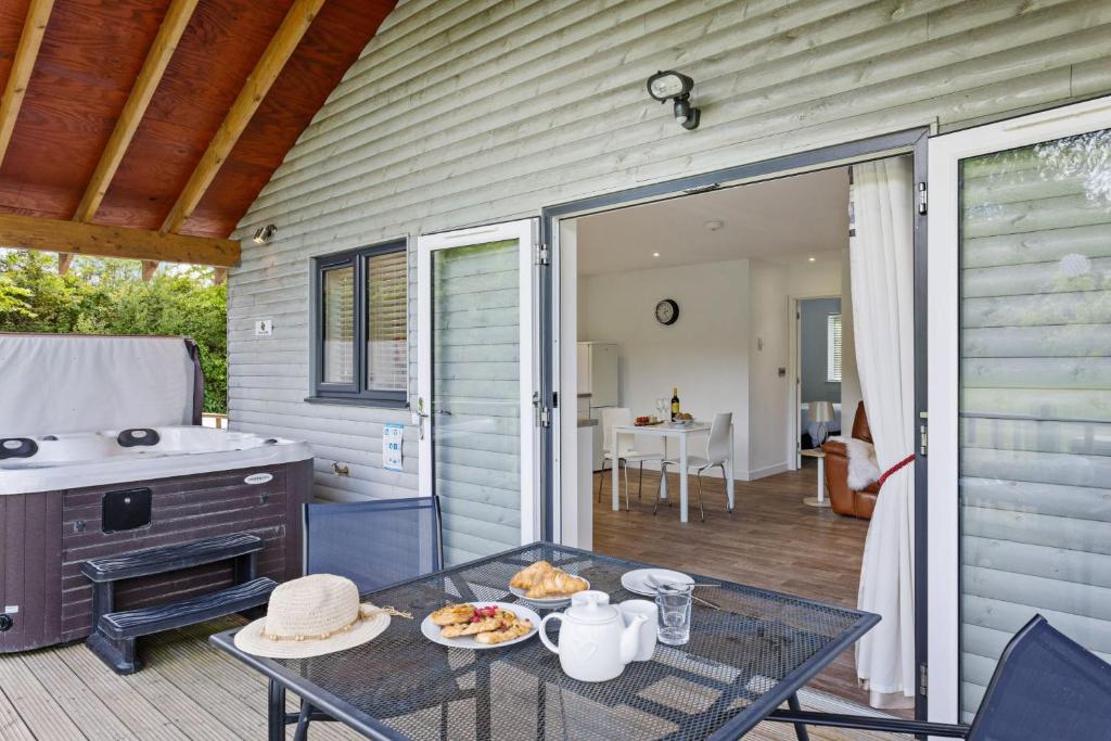 a patio with a table with food on it at The Clover Lodge, Red Lake Farm Nr Glastonbury in Somerton