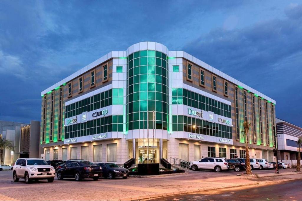 a large building with cars parked in front of it at Duset Suites in Riyadh