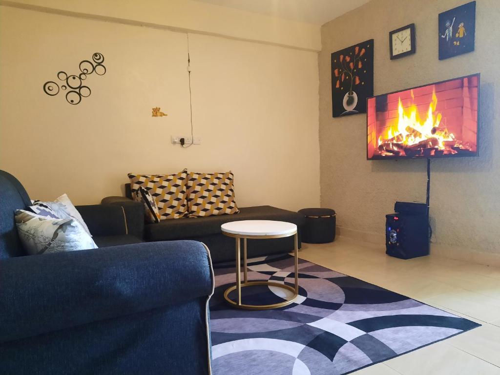 ein Wohnzimmer mit einem Sofa, einem Tisch und einem Kamin in der Unterkunft La Casa Nakuru in Nakuru